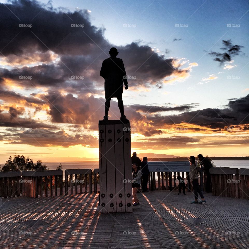 Visitors enjoy the sunset from Captain Cook's statue at Resolution Park, Anchorage, Alaska