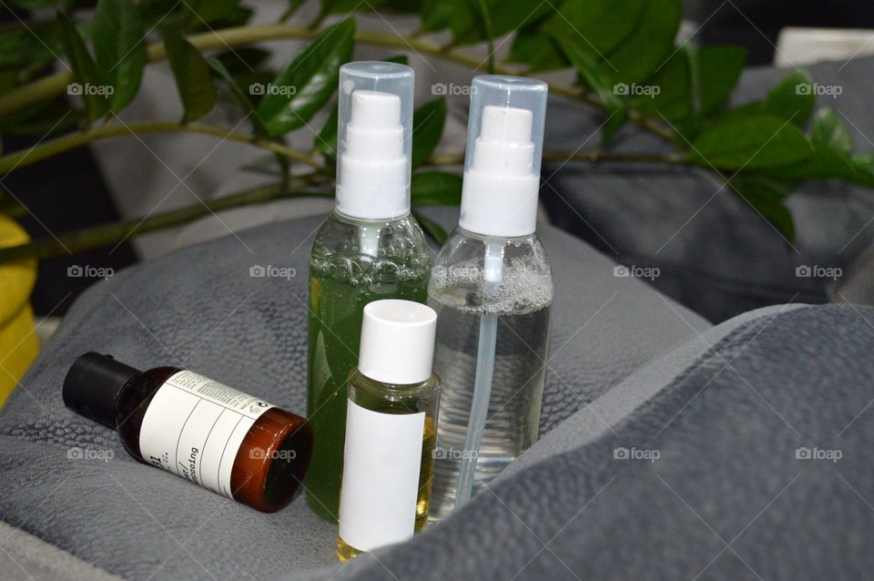 Jars with cream, shampoo and cosmetics on a background with green plants