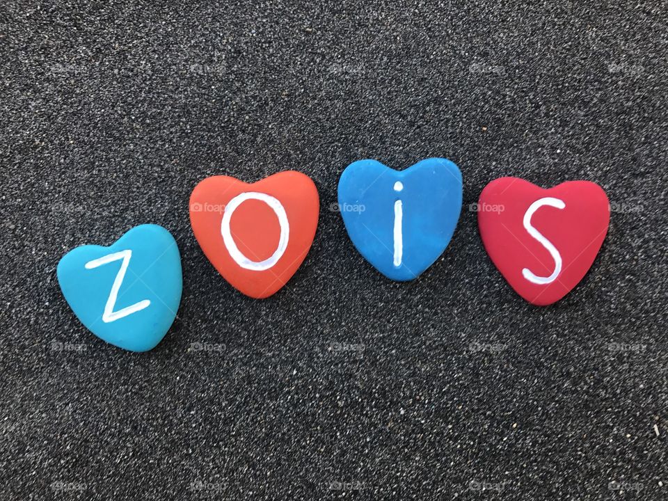 Zois, greek origin masculine name with colored heart stones over black volcanic sand