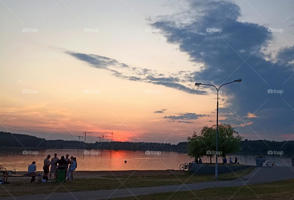 people on a lake, evening sunset,summer in the city