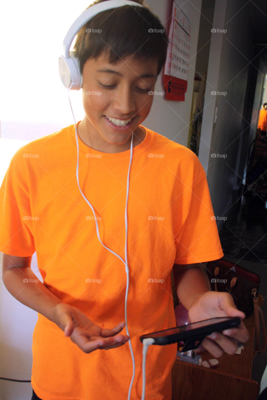 Teen boy with headphones and smartphone