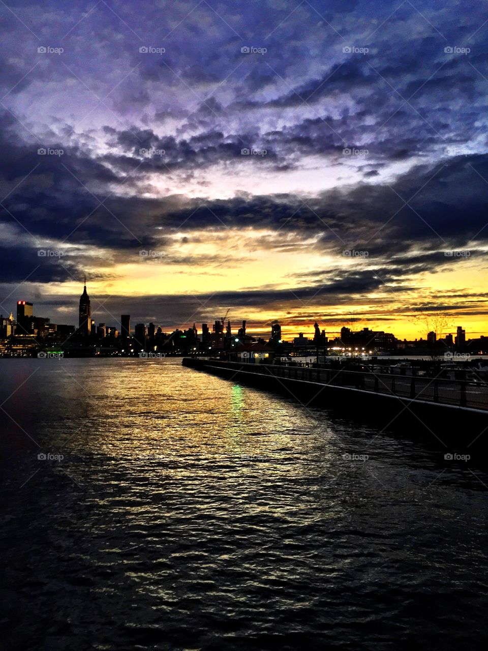 New York City skyline at sunrise with purple skies.. New York City skyline at sunrise with purple skies. Hudson River view,