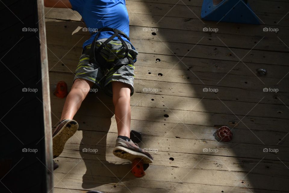 Young Boy Ascends A Climbing Wall