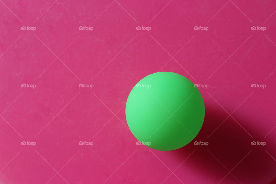 green ball on fuchsia background