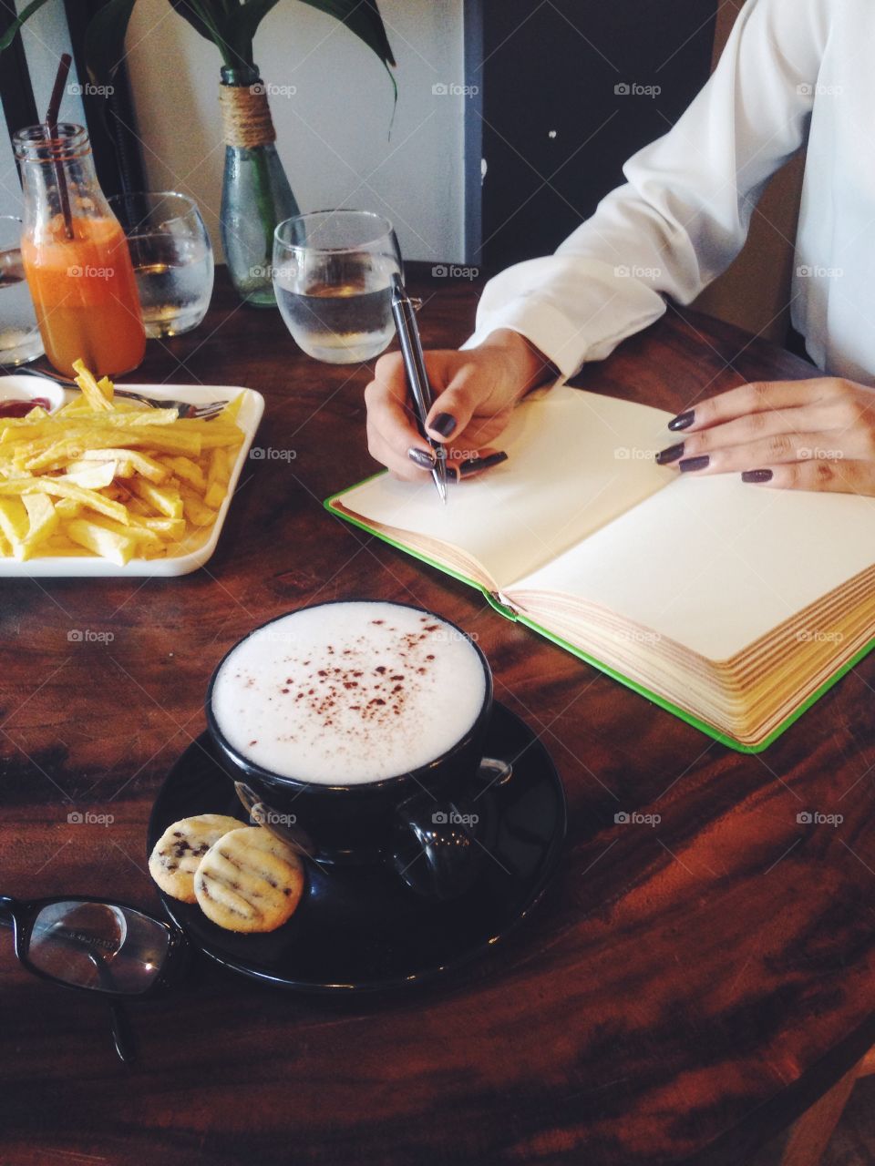 Woman writing in her diary at a coffee shop