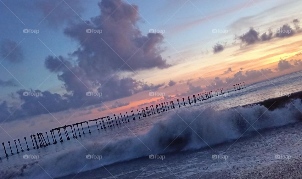 colourful ocean beach sunset with deep blue sky and sun rays in Kerala
