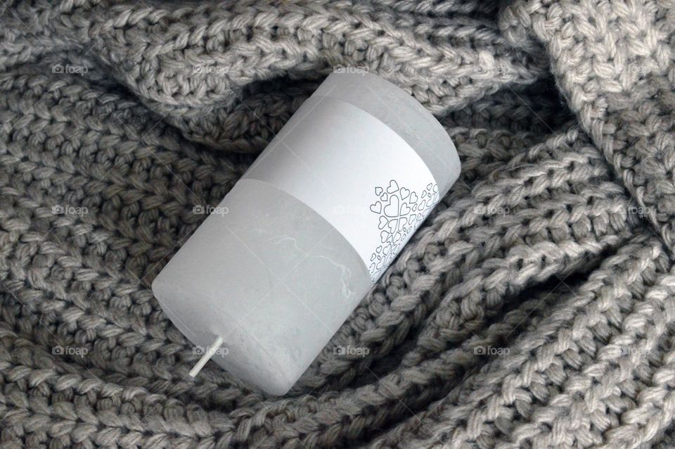 White candle on a knitted background