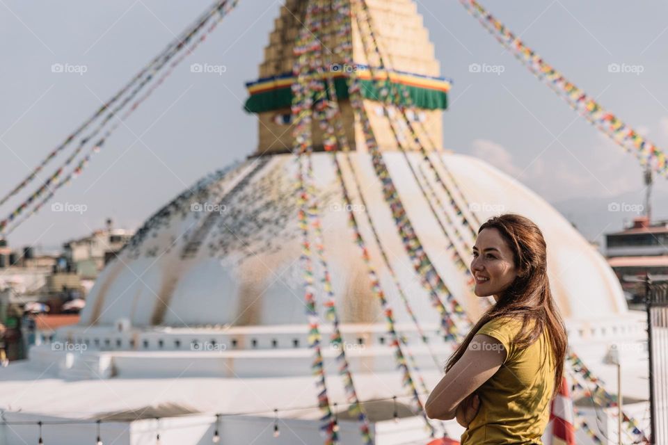 Beautiful young woman standing in front of the biggest Stupa in Nepal, called Boudhanath, located in Kathmandu.