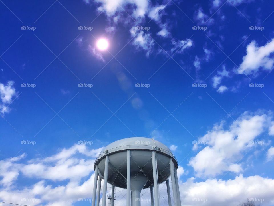Water Tower. A water tower against a deep blue sky & sunshine. 