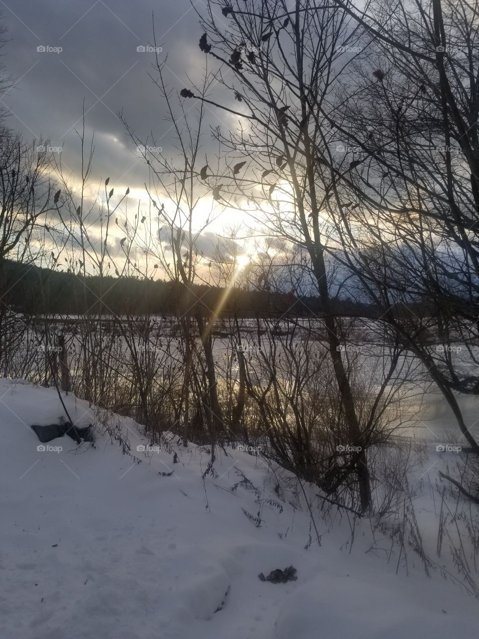 Sunset gleaming through wintery cloudy sky.