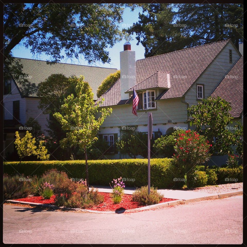 house on the corner. a picturesque house with an american flag on the corner of a small town street in paso robles, ca