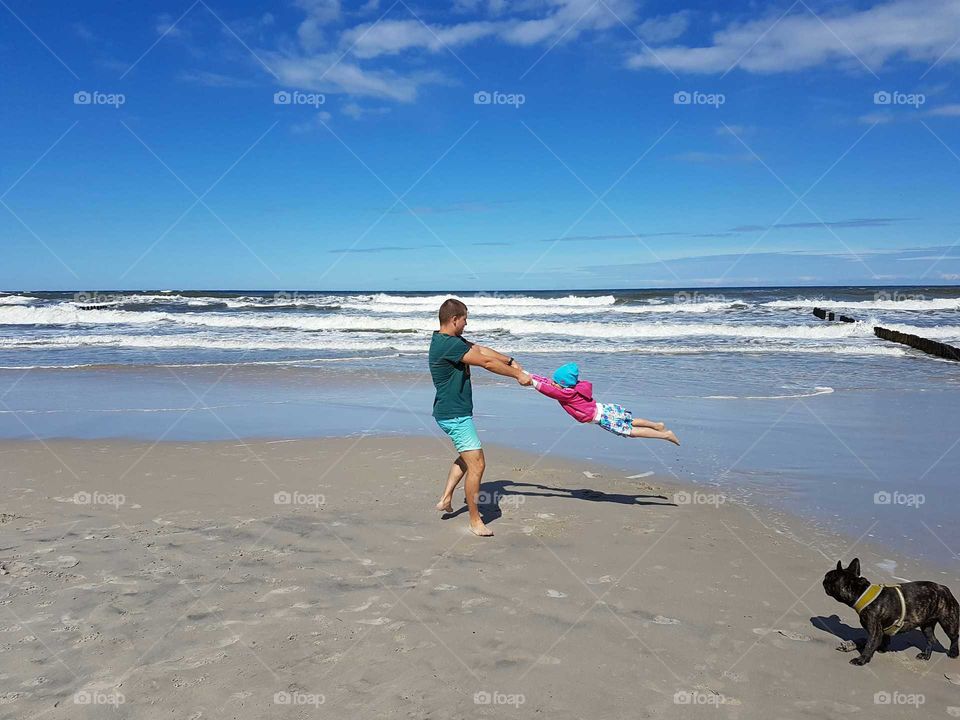 Father and daughter playing on the beach