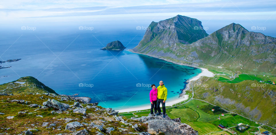 Happy couple standing on top of mountain near ocean