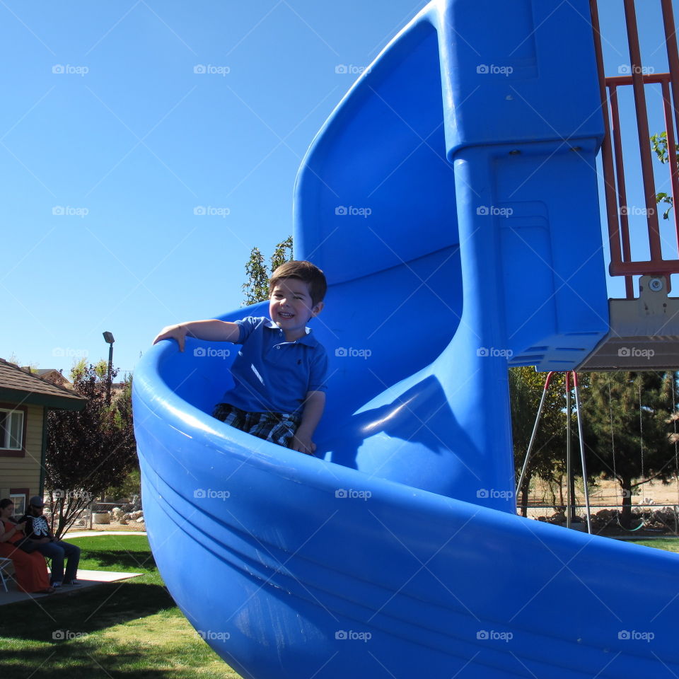 Little boy playing on slide
