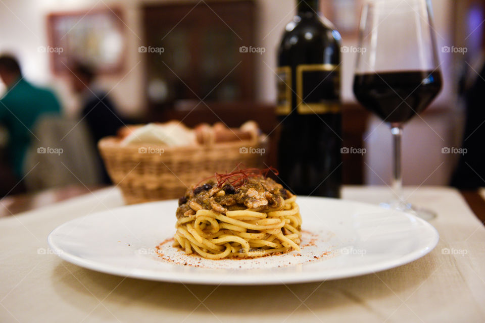 Pasta dish at the restaurant in Sicily with red wine and bread.