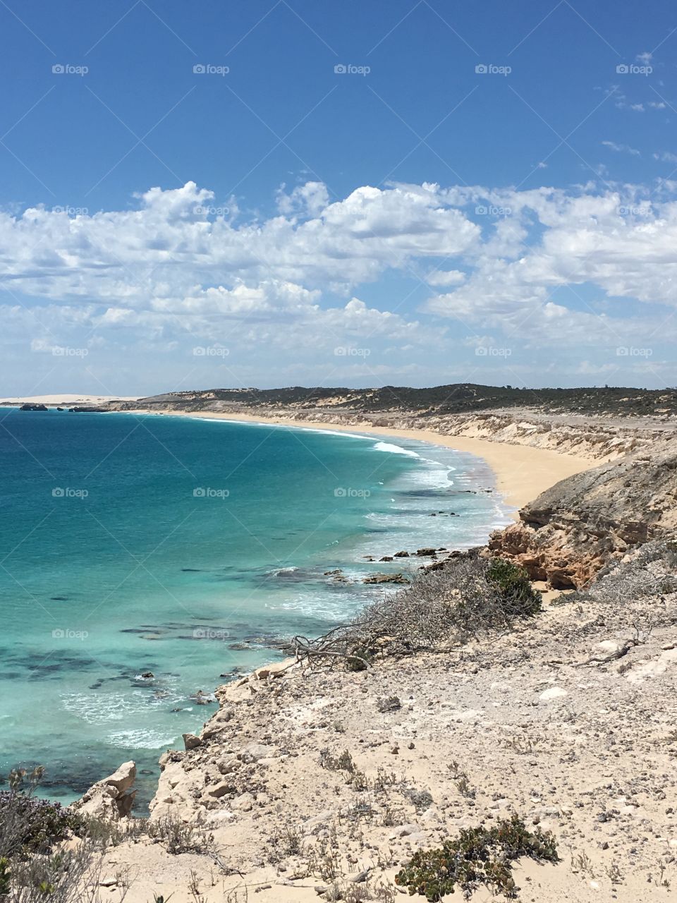 Sea cliffs, sand dunes, surrounding a beautiful turquoise blue ocean bay in south Australia in a remote are of Coffin Bay near the national park. 