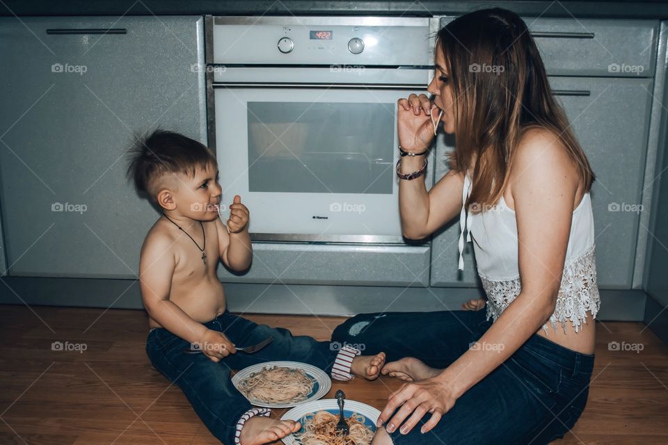 mom and son eat pasta in the kitchen