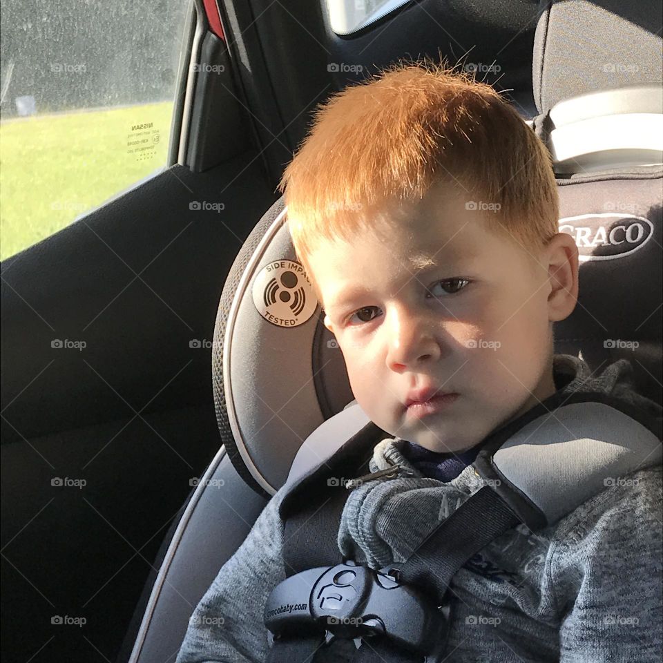 Portrait of a red-haired child in the car