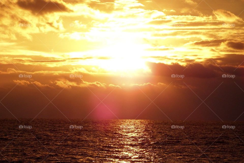Scenic view of sea against dramatic sky during sunset