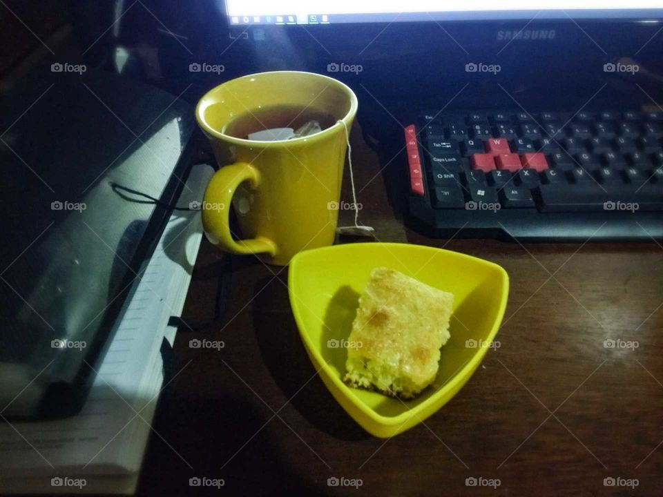 coffeebreak with hot tea and orange cake in the home office
