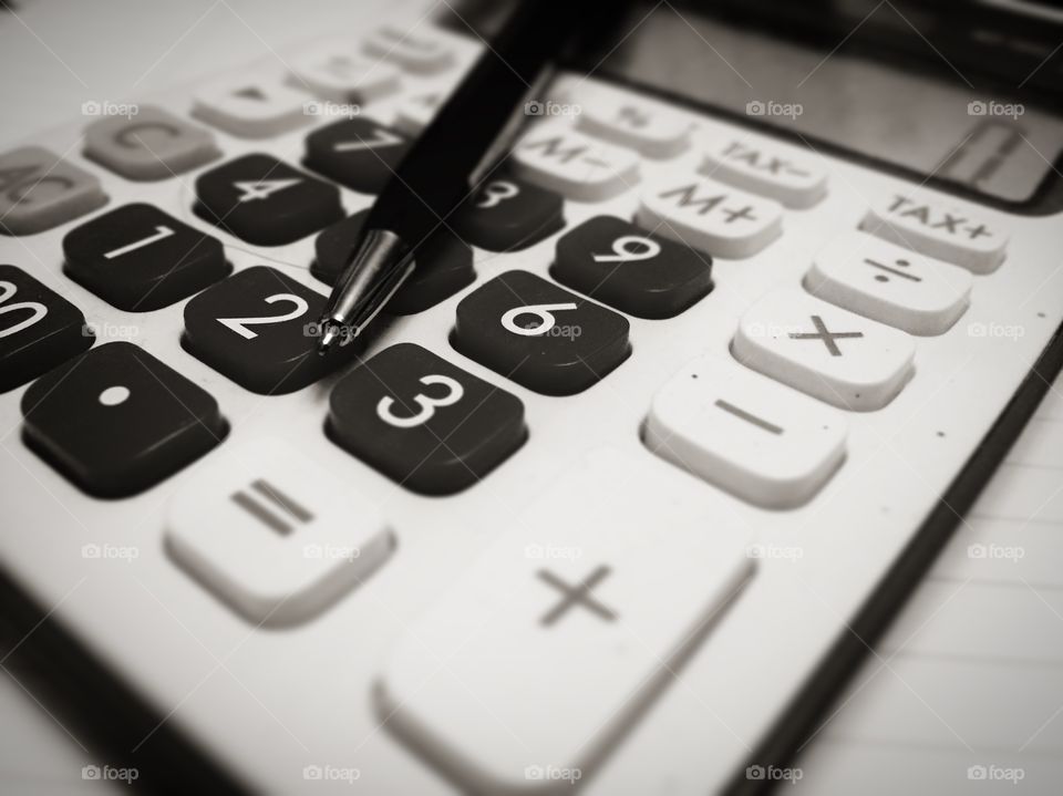 Calculator and pen in black and white