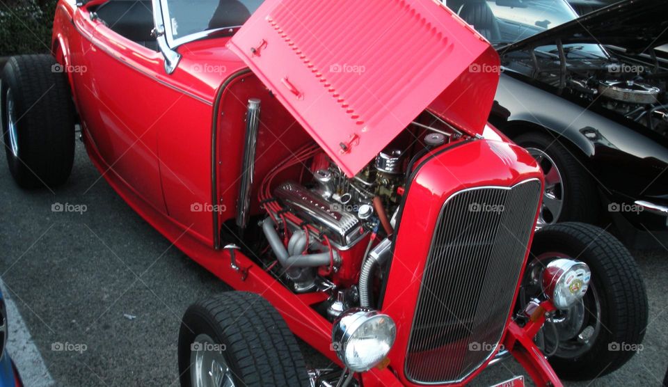 red classic car close-up of open hood with exposed engine