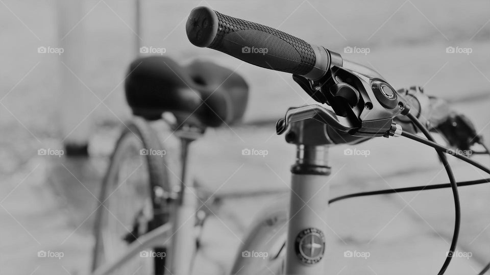 Bicycle at rest handle bars foreground cropped body bokeh background 