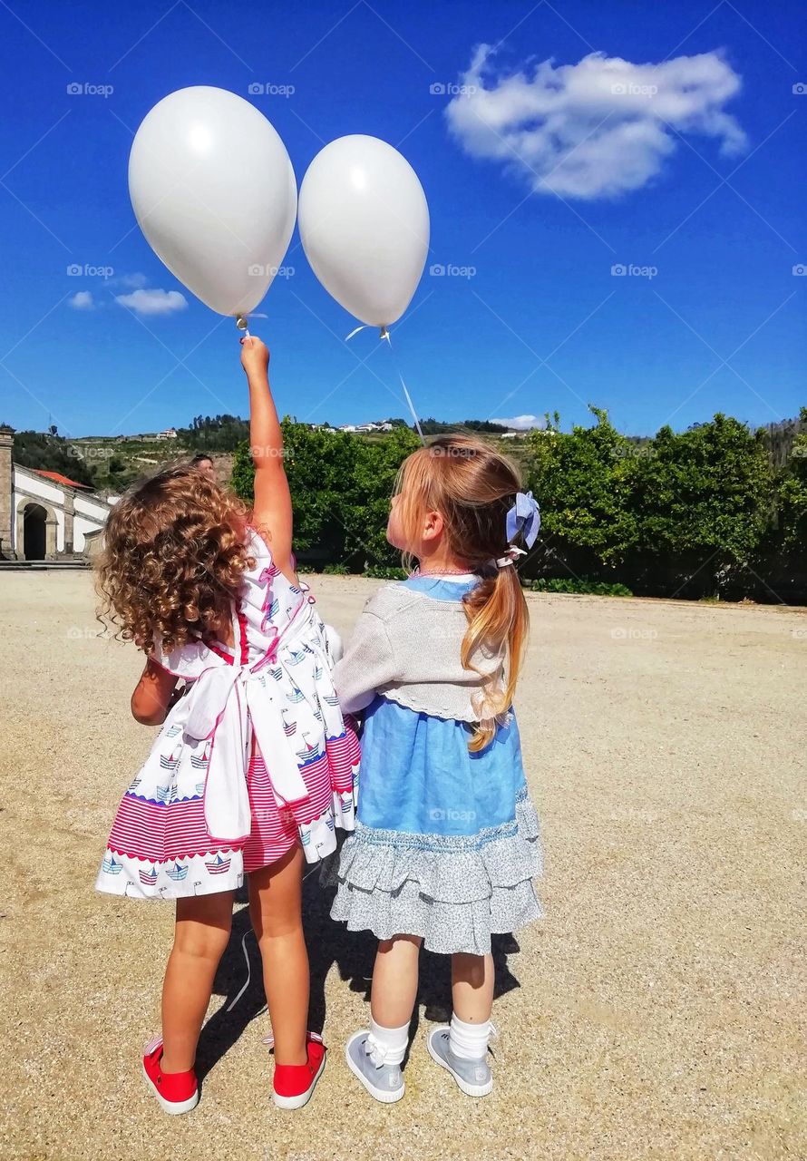 Little girls holding helium balloons