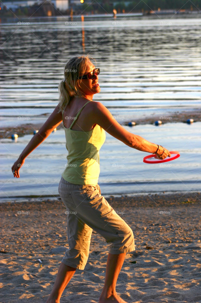 Playing frisbee in the glow. A game of frisbee on the beach in the golden glow of the sun