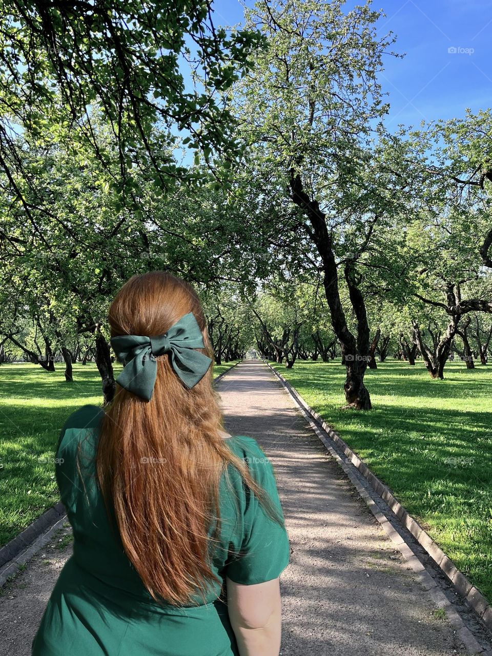 A woman in a green dress and a green bow in her hair