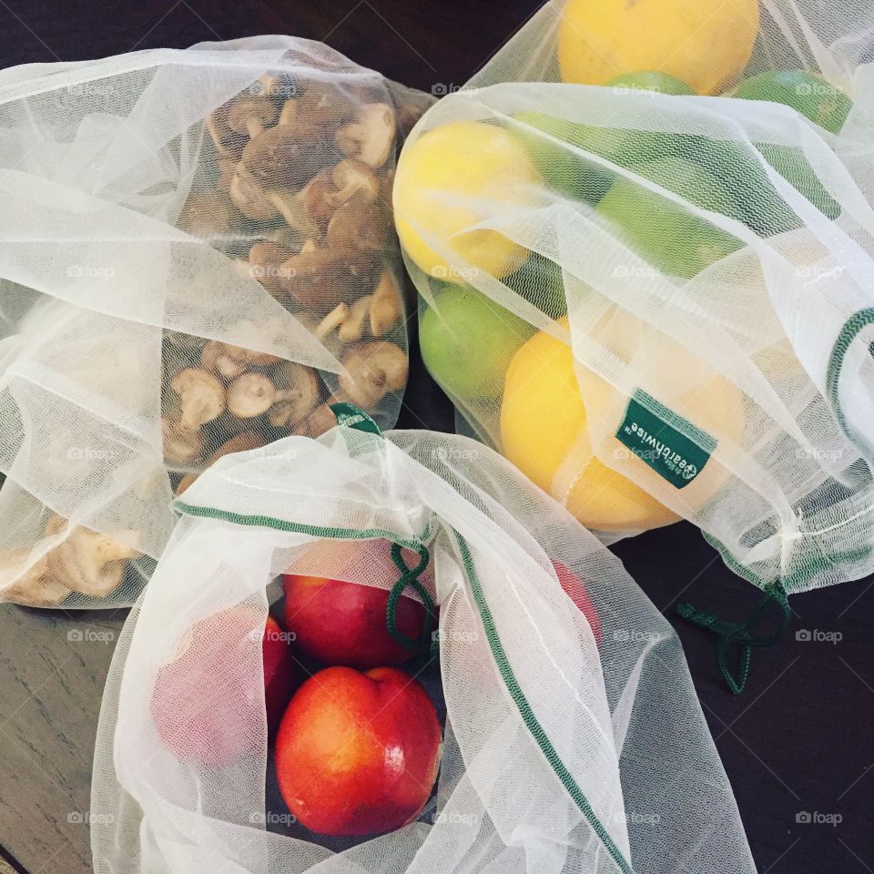 Eco friendly mesh produce bags filled with fruits, citrus, mushrooms