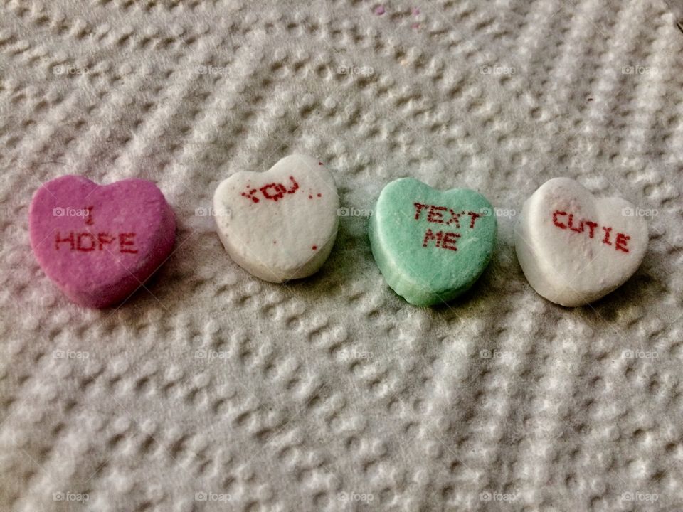 Candy conversation hearts spelling out "I hope you text me, cutie"