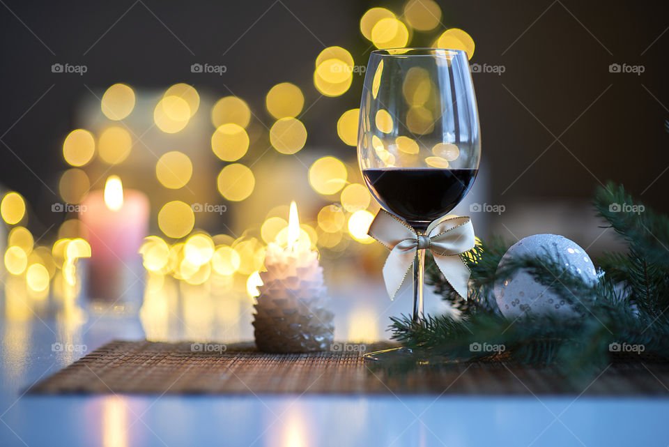 Festive Christmas mood with a glass of wine and burning candle on the kitchen dinner table