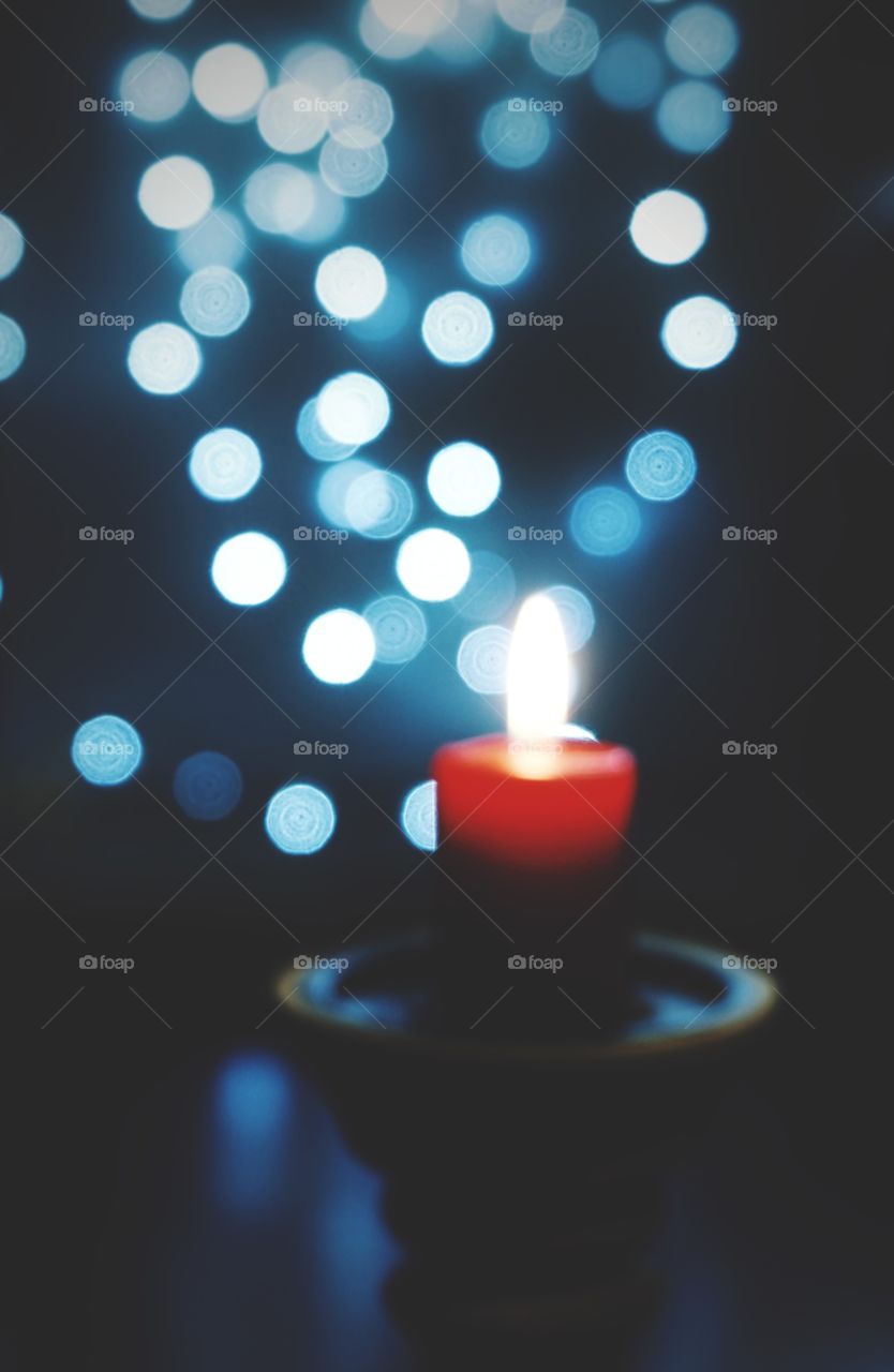 Candle red color flame close-up blur blue background lights illuminated decoration celebration winter
