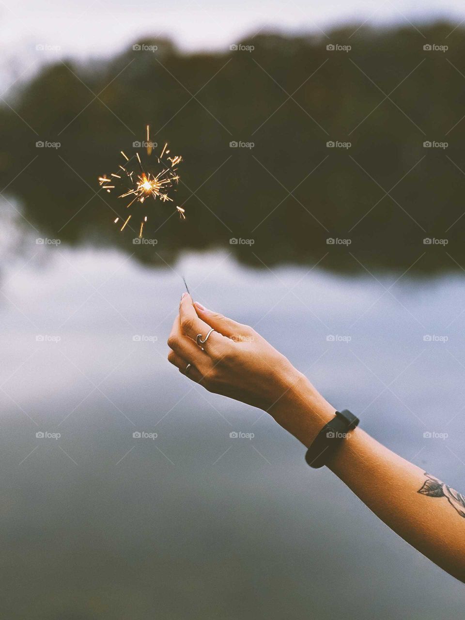 A hand holding up a sparkler