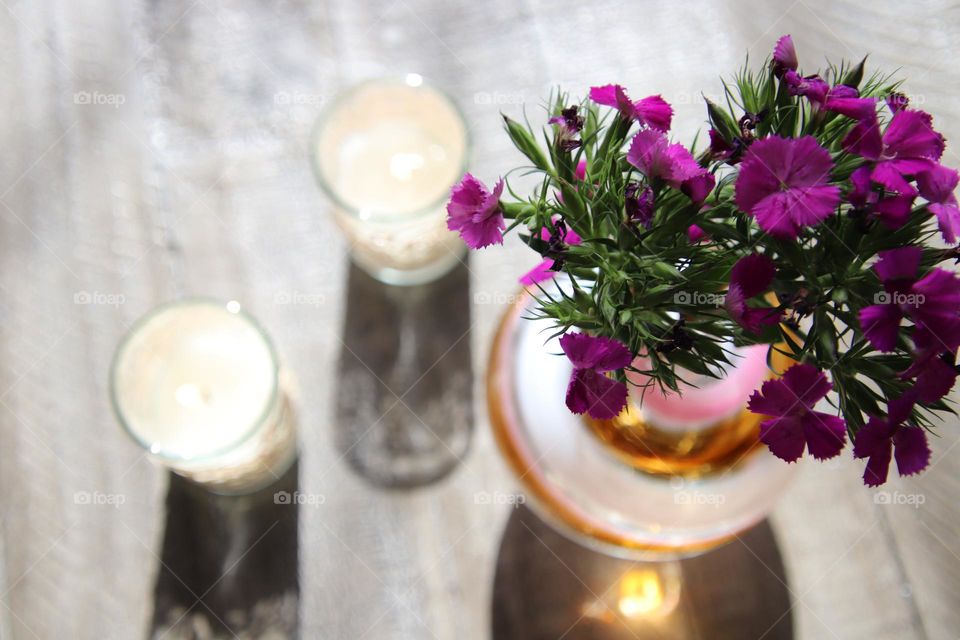 Beautiful purple wild flowers in white, pink, purple and brown vase with sun shining through