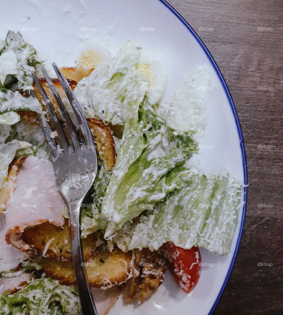 Caesar salad with chicken and egg on a white plate
