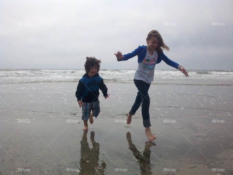 Sibling running at beach