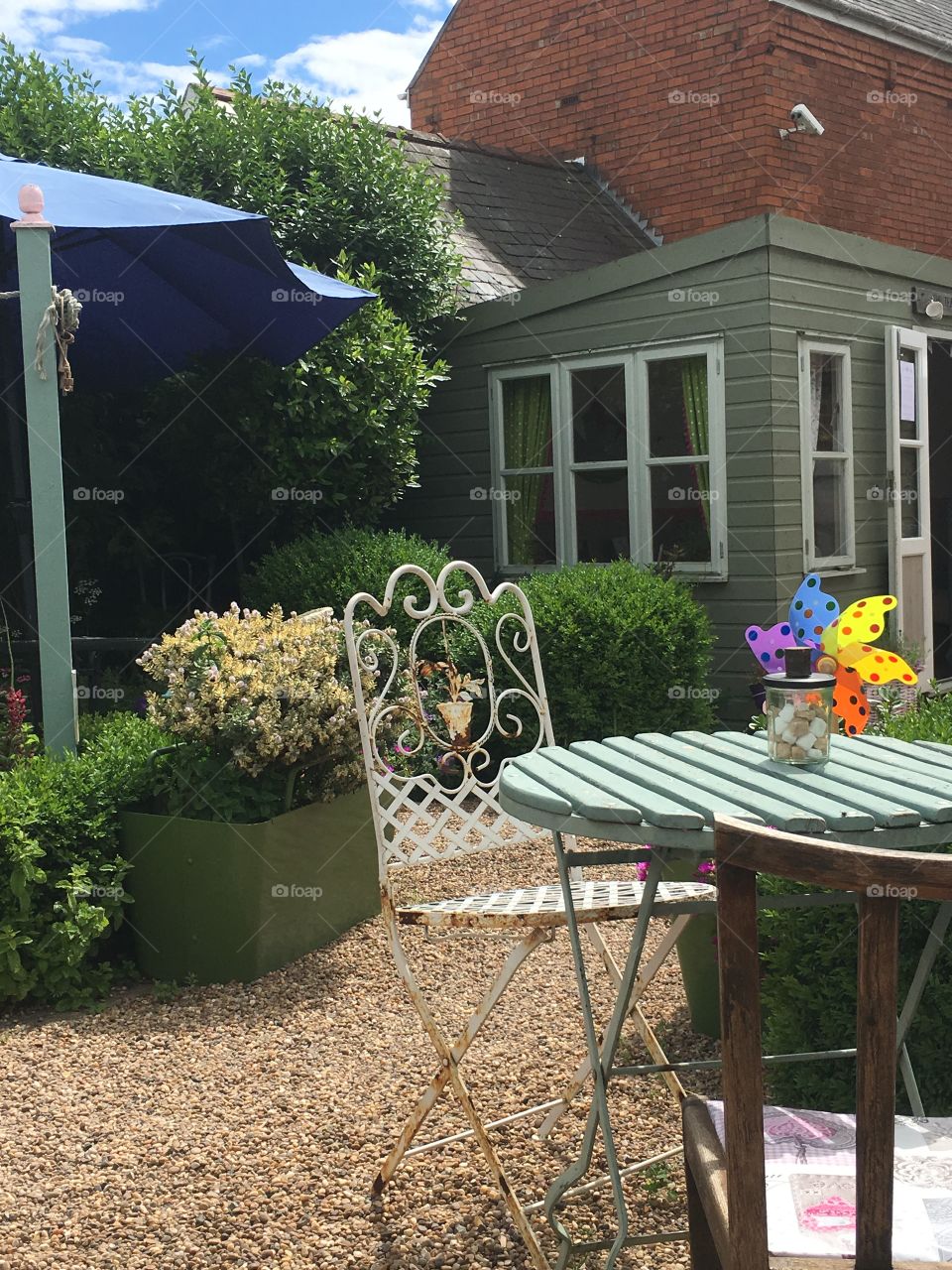 Table and chairs outside in the garden at a tearoom surrounded by plants 