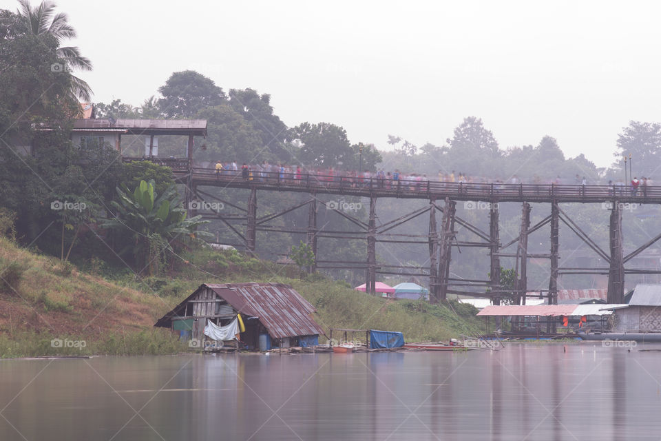 House in the river and the wood bridge from behind in Sagklaburi Kanchanaburi Thailand 