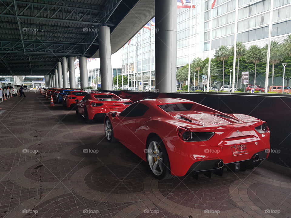 Red Ferrari 488 spider twin-turbocharged V8 luxury sports car parked in line