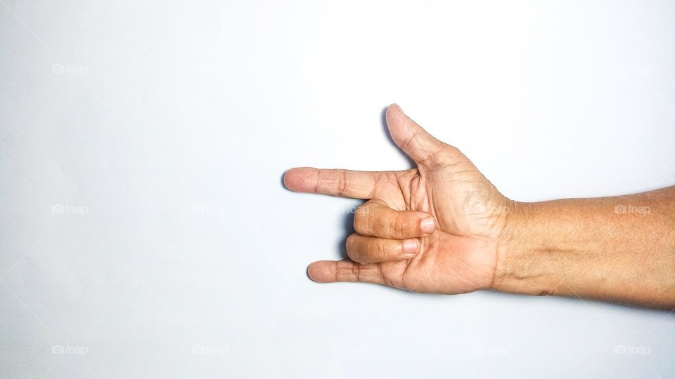 The palm is holding up three fingers to form a metal symbol in eye level view