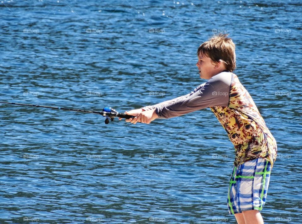 Young Boy Fishing In A Mountain Lake
