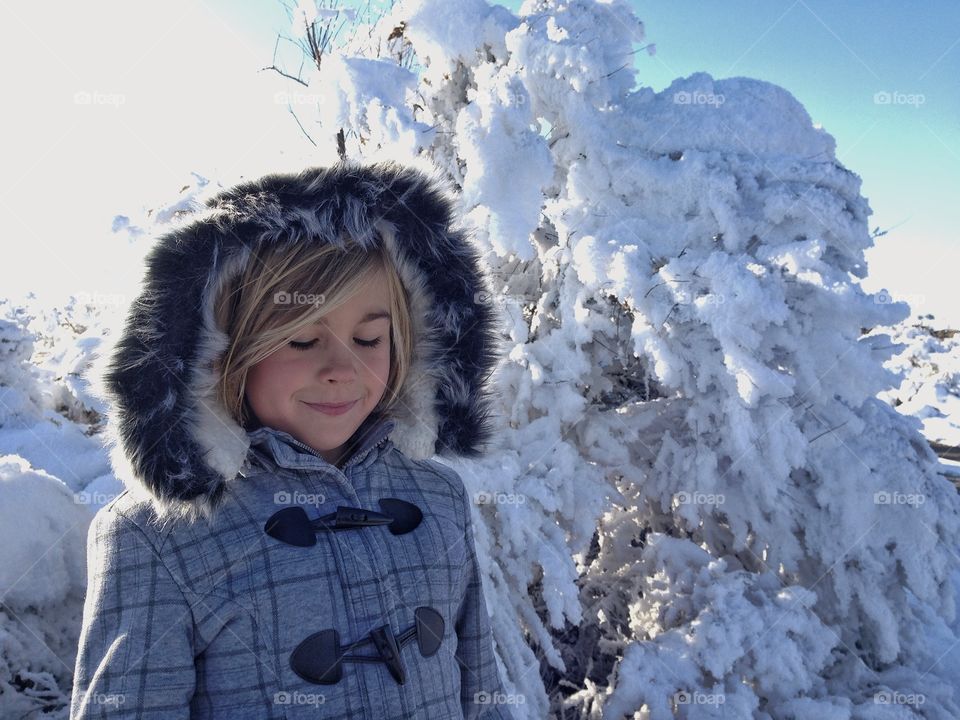Girl standing in front of frozen tree