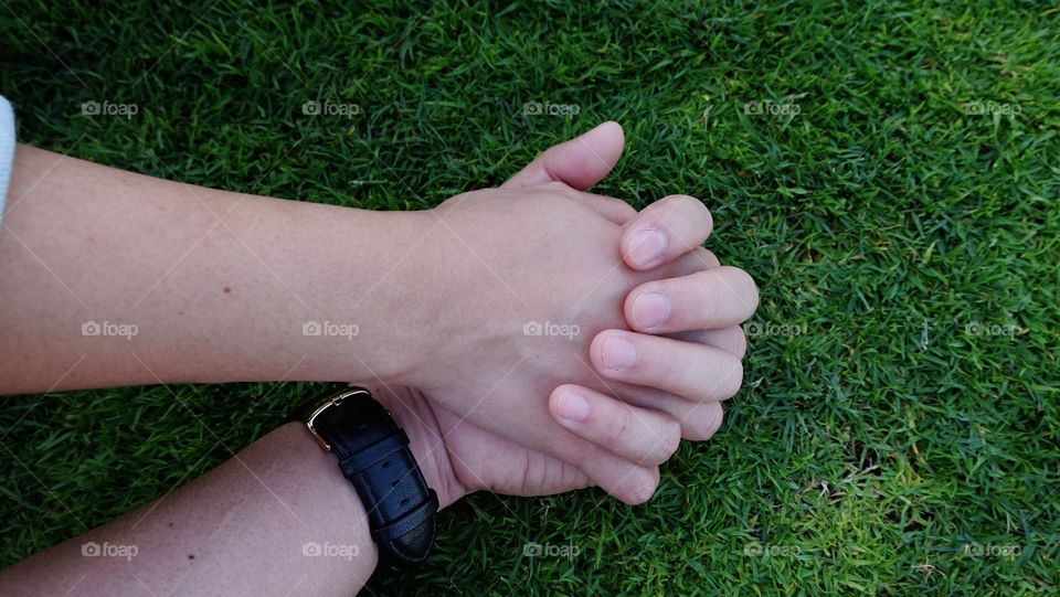 Close-up of holding hands on grass