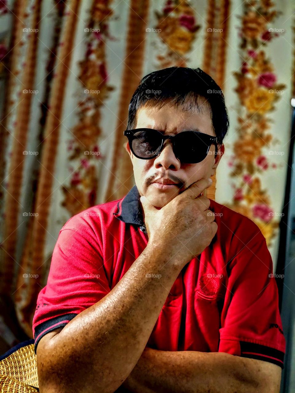 A man with mustaches wearing sunglasses.