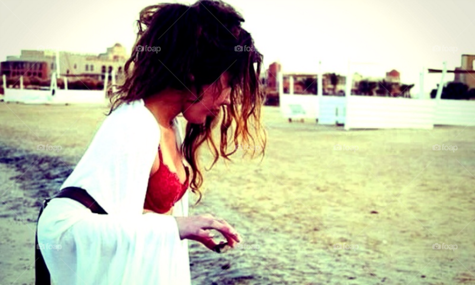 Girl on beach. Young girl picking stones at a beach in Egypt