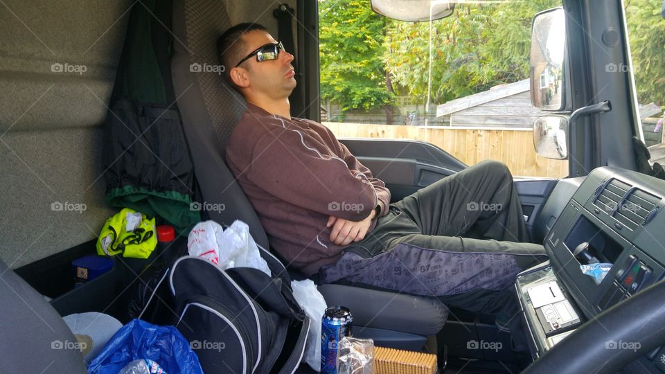 A handsome man sitting on front seat of bus