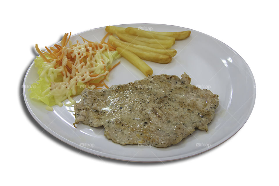 Isolated Pork steak with French fries and salad on a white background with clipping path.