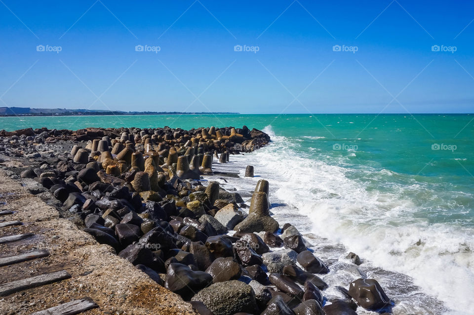 Dolos and boulders combating the waves at the Oamaru Breakwater, New Zealand 